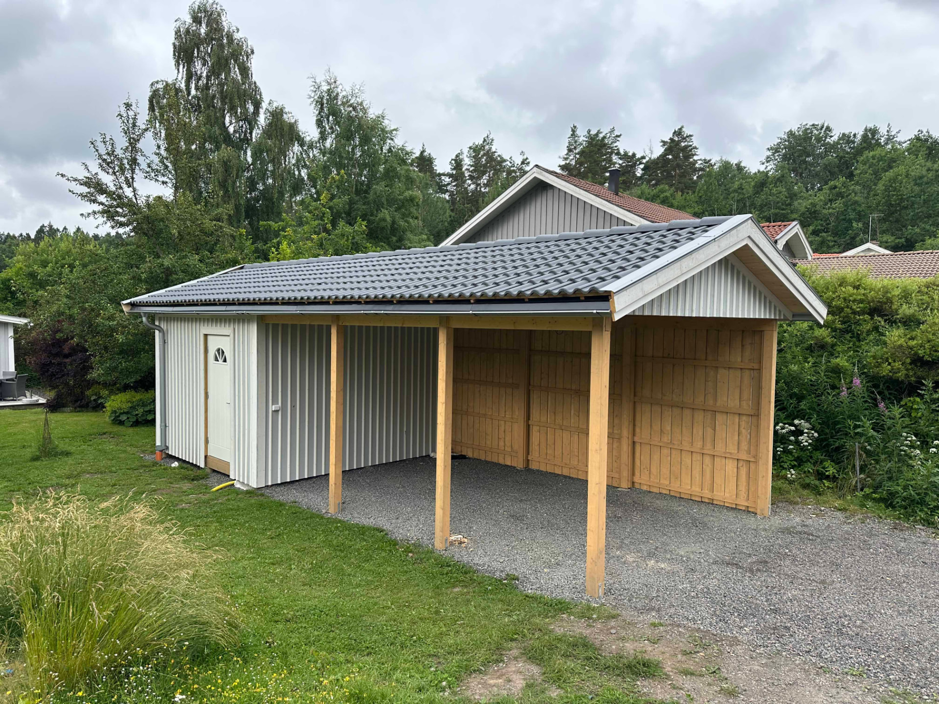 Färdig carport med förråd i lösvirke och betongpannor på Torkels väg